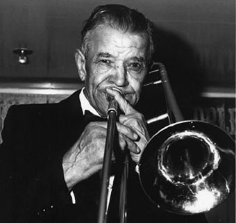 Fotografía en blanco y negro de Edward Ory aparentremente accionando un trombon